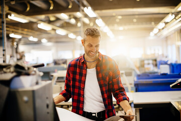 Male factory worker working in industrial printing office