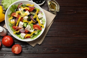 Delicious fresh Greek salad served on wooden table, flat lay. Space for text