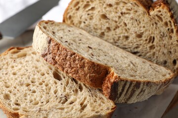 Cut loaf of fresh bread on table, closeup