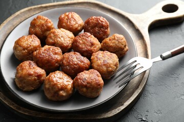 Tasty cooked meatballs served on grey table, closeup