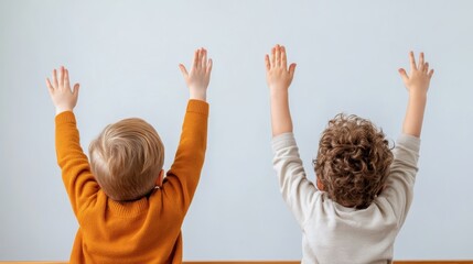 Two young boys with curly hair eagerly raise their hands in excitement and curiosity, showcasing the joyful essence of childhood and the quest for knowledge.