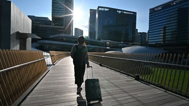 キャリーケースを持った女性旅行者の後ろ姿
