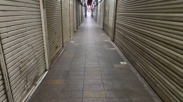 シャッターが閉まった通路を歩くスローモーション
