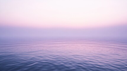 Serene landscape of calm water at sunrise with soft pastel hues.