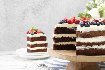 Delicious chocolate sponge cake with berries served on white table