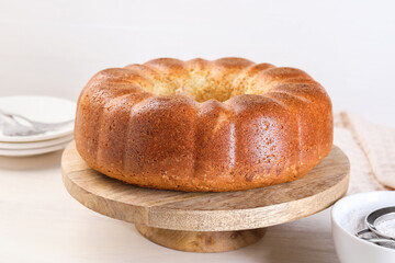 Freshly baked sponge cake on white wooden table, closeup