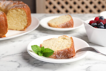 Freshly baked sponge cake, mint and berries on white marble table, closeup