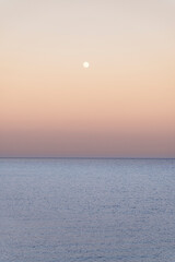 The view after sunset by the sea and the full moon in the sky