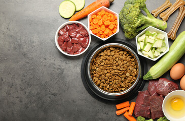 Dry pet food and natural products on grey table, top view. Space for text