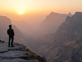 Fototapeta premium Person Standing on Cliff at Sunset