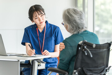 肩こり・肩を痛がる高齢者・シニア女性と介護施設・病院で働く整形外科の医師・看護師・介護福祉士
