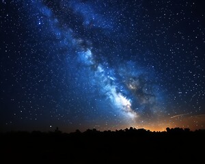 Milky Way galaxy at night over dark horizon.