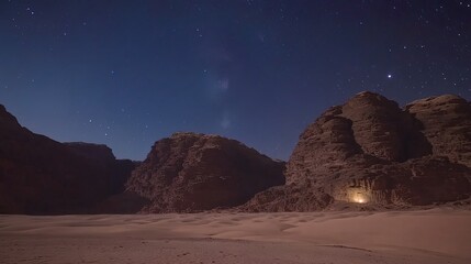 Starry night sky over desert landscape with illuminated cave.