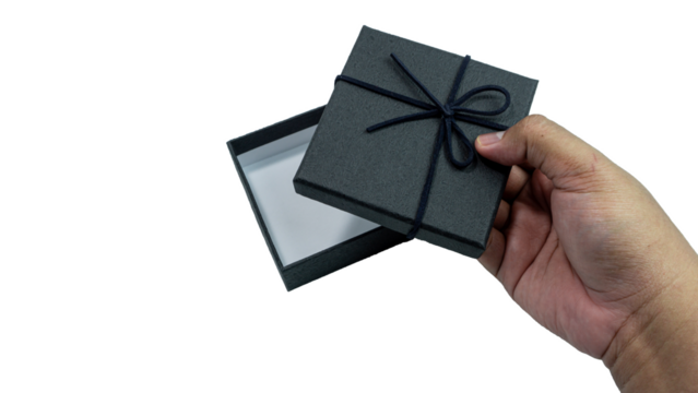 Black gift box with texture with black ribbon isolated on transparent background background. Black box being held in hand. transparent object