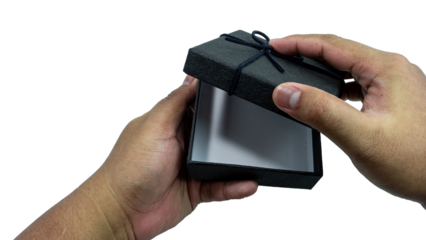 Black gift box with texture with black ribbon isolated on transparent background background. Black box being held in hand. transparent object