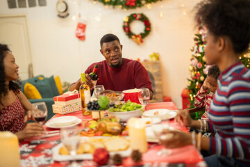 A warm Christmas family dinner with a father serving food to his young child, surrounded by festive decorations, a Christmas tree, and a holiday table spread. Joyful and cozy holiday atmosphere.