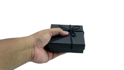 Black gift box with texture with black ribbon isolated on transparent background background. Black box being held in hand. transparent object