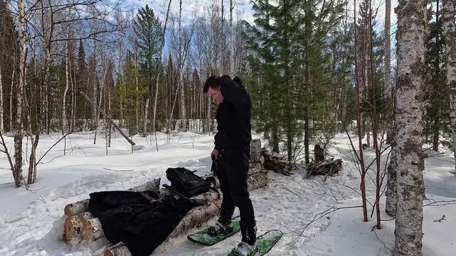 undressing in winter. a man takes off his fur coat in winter at a bus stop