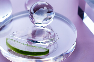 Aloe vera slice and serum droplets rest on a glass dish, emphasizing a clean spa atmosphere.