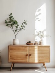 Light wood cabinet styled with plants and vases
