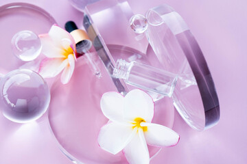 Display includes serum with aloe and centella, surrounded by glass elements and flower petals. Flat lay.