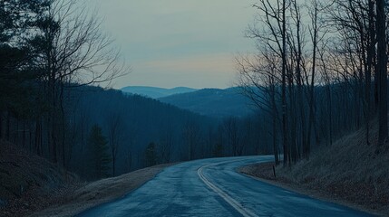 Obraz premium Winding road through hills at dusk.