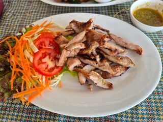 Grilled and roasted marinated pork belly serving on the plate. Famous local street food menu in Asia. 