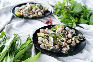 Plates of clams and mussels with garlic and vibrant green herbs ready for a seafood feast.
