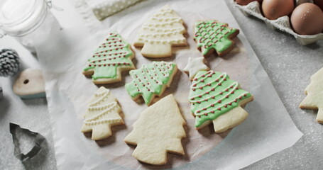 Merry christmas text in red over decorated christmas cookies and on kitchen worktop