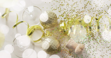 Image of spots of light over gold confetti and champagne glasses