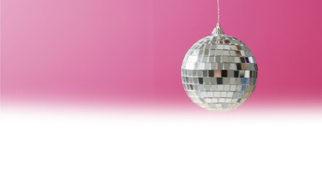 Fototapeta premium Image of disco ball spinning on pink background