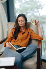 Young woman enjoying a sandwich and reading a book while relaxing in a cozy setting, exuding calmness and contentment in autumn tones