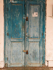 The ancient house door is locked with an ancient padlock and the air vents are carved in the form of iron.