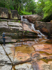 Aerial drone view of an amazing waterfall with unique rocks formations at Batu Ferringhi, Penang Island, Malaysia.