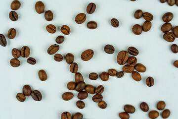 Scattered roasted coffee beans on white background
