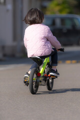 Obraz premium 自転車練習を頑張る幼い女の子の後ろ姿