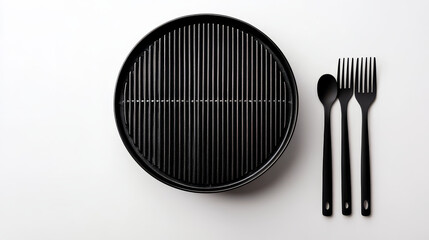 Minimalist view of empty round grill with black utensils on white background, showcasing simplicity and elegance in kitchenware