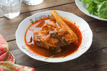 Asam Pedas Ayam is a flavorful Malaysian dish featuring chicken cooked in a tangy, spicy tamarind-based broth.