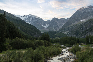 Alpine Valley with river, mountains and glaciers, in summer at sunset. Macugnaga in Anzasca Valley and Monte Rosa, Italy