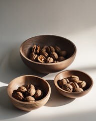 Obraz premium Walnut halves filling three wooden bowls