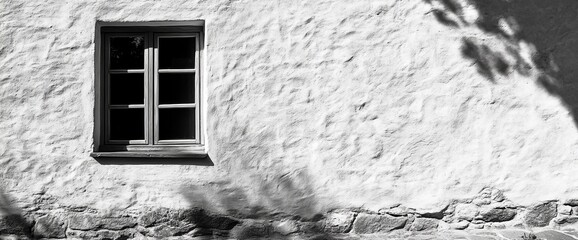 Black and white photo of a single window on a textured wall.