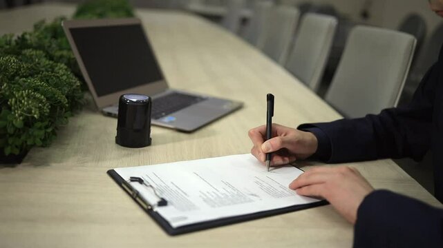 Official representative signing legal documents at contemporary workspace. Business person sings long-term contract during corporate meeting. Business meeting concept.