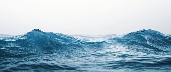 Dramatic ocean waves under a misty sky.