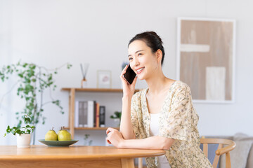 自宅で電話する若い女性