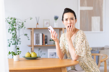 スマホで驚く若い女性