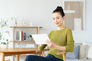 自宅でタブレットを使う若い女性