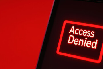 Access denied message displayed on laptop screen with red background, conveying sense of restriction and urgency