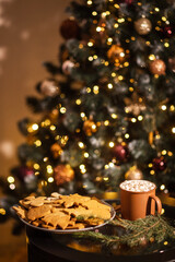 beautiful christmas gingerbread cookies and cup of cocoa with marshmallows on new year bokeh background.