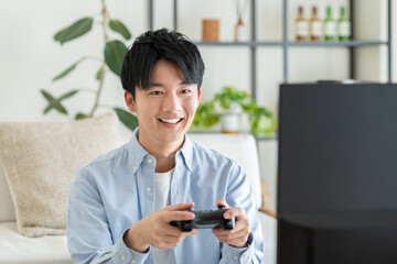 テレビゲームをする若い男性