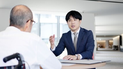 高齢者に営業をするビジネスマン